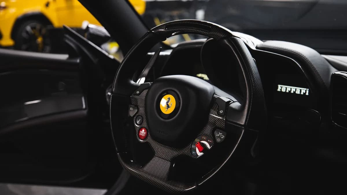 Stylish interior of a luxury car featuring a carbon fiber steering wheel and modern dashboard.