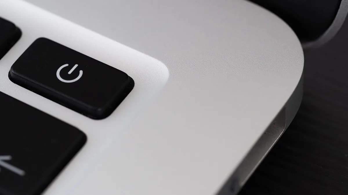 Detailed view of a power button on a sleek laptop, emphasizing technology design.