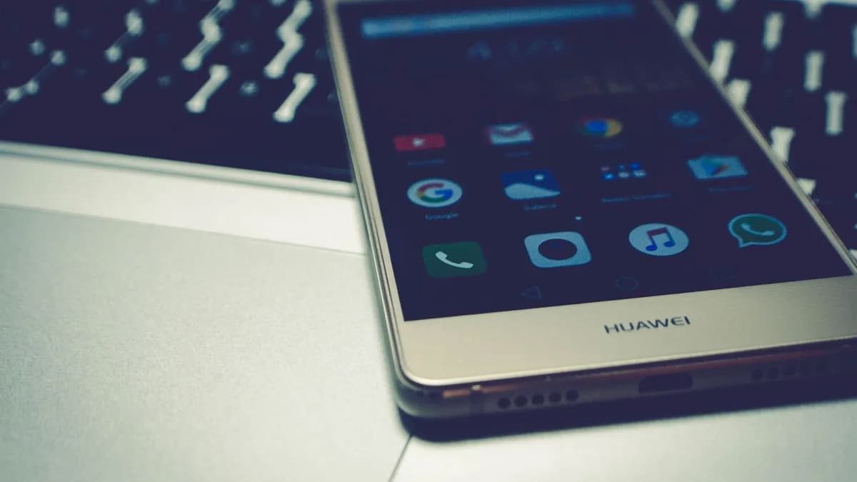 Close-up of a smartphone placed on a laptop keyboard, highlighting digital interaction.
