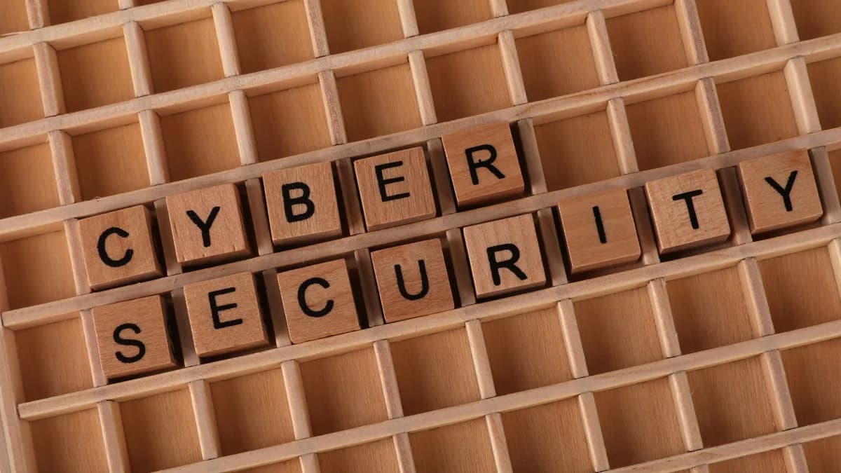 Wooden blocks spelling 'Cyber Security' on a wooden grid background.
