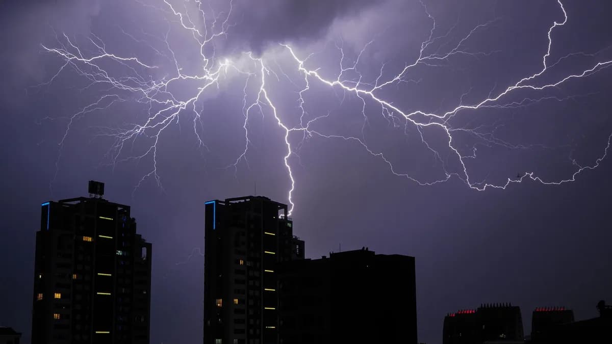 Stunning view of lightning bolts illuminating a cityscape at night, creating a dramatic and powerful scene.