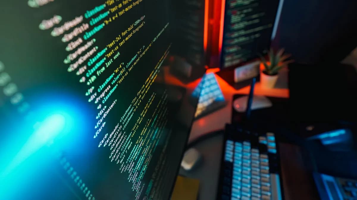 Futuristic workspace featuring a glowing computer screen with coding displayed, ideal for technology and programming concepts.