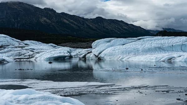 Pristine glacier landscape with icy lake in a remote mountainous region.