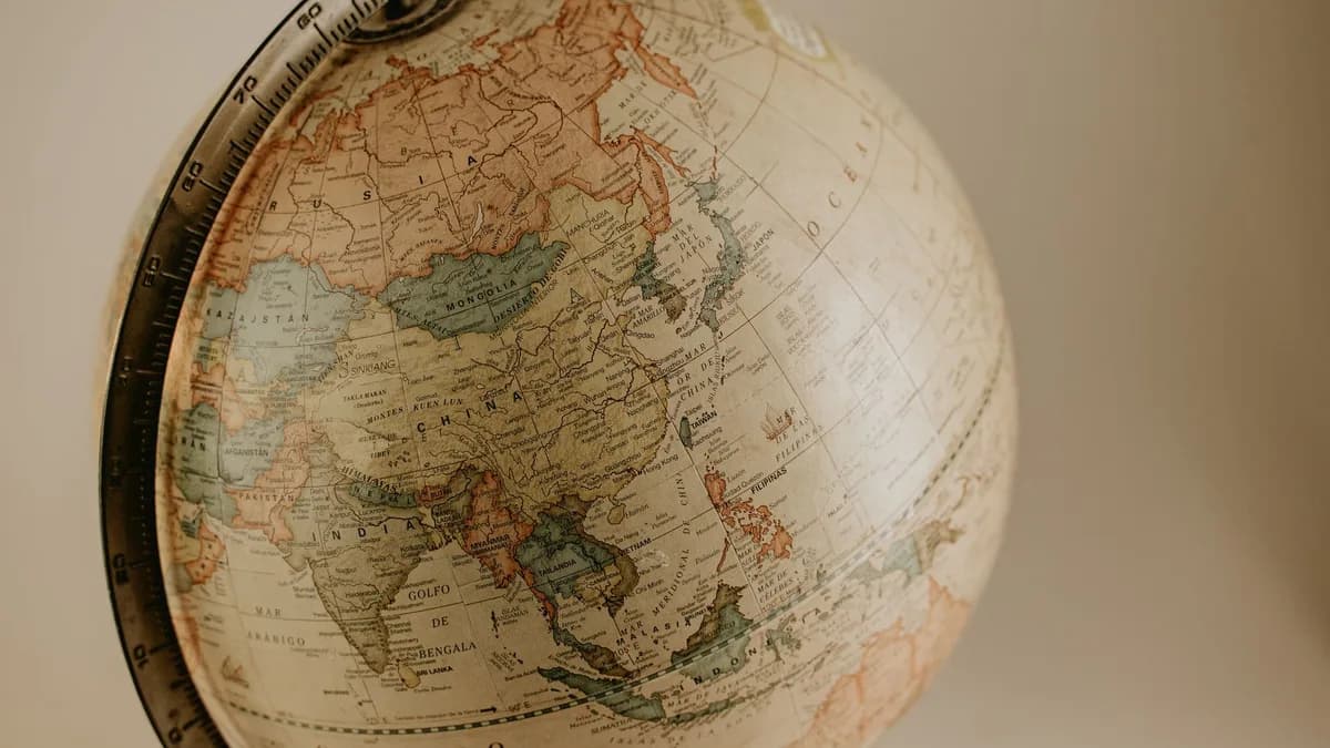 A vintage globe displaying the continents of Asia and Europe in sepia tones, ideal for travel concepts.