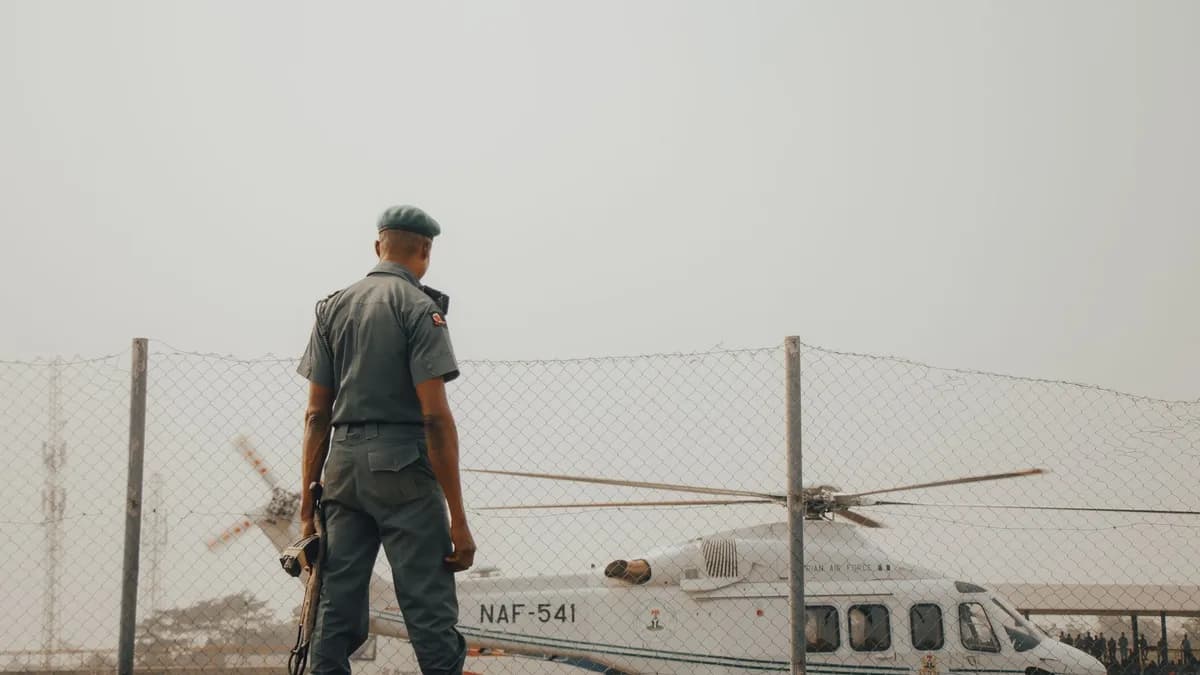 A military officer stands watch by an NAF helicopter fenced area in Nigeria.