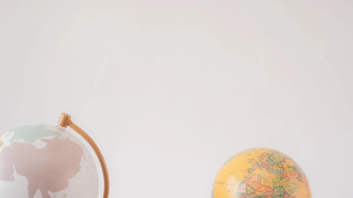 A minimalist image showcasing two globes against a light gray background offering ample copy space.