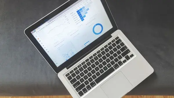 Overhead view of a laptop showing data visualizations and charts on its screen.