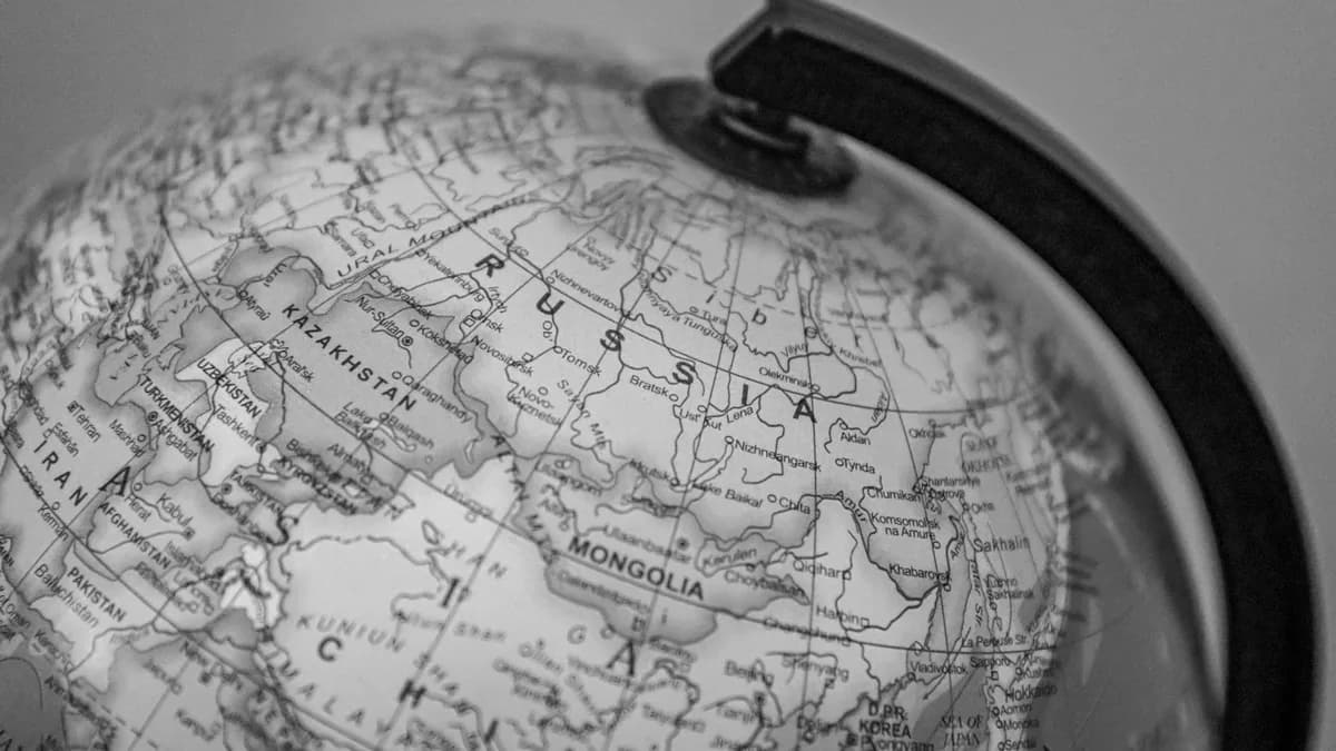 Black and white close-up of a globe focusing on Russia and surrounding countries.