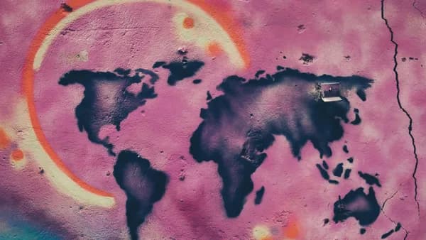 Colorful graffiti art depicting a world map on a cracked urban wall in Jerusalem.