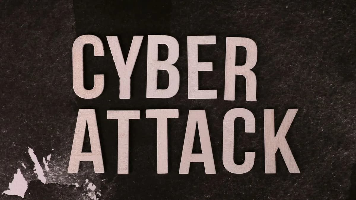 Text 'Cyber Attack' on textured dark paper highlights digital security threat concept.