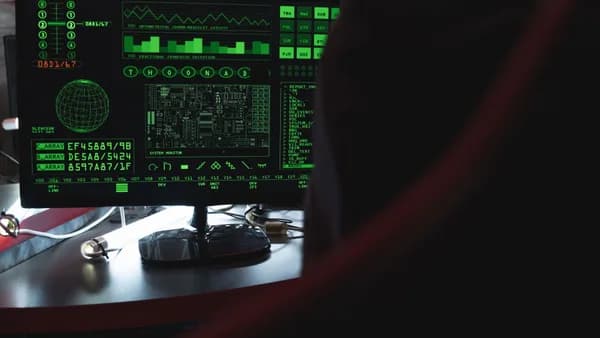 View of a computer monitor displaying green digital security code in an indoor setting.