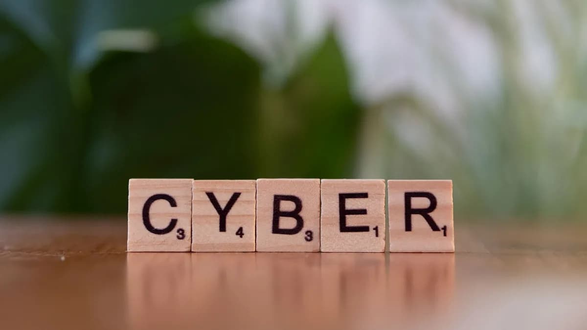 Wooden letter tiles spelling 'CYBER' on a blurred background, representing cybersecurity.
