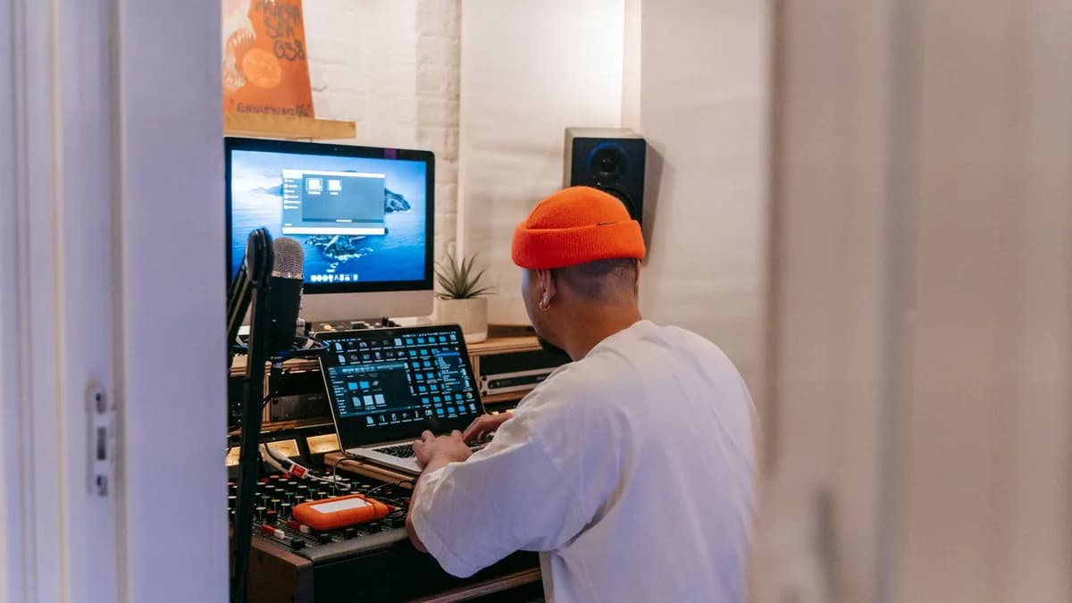 A music producer in a home studio using advanced technology to create music.