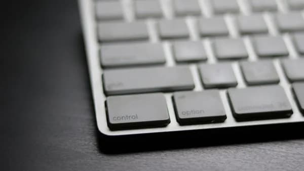 Detailed close-up of a sleek modern wireless keyboard on a dark surface.