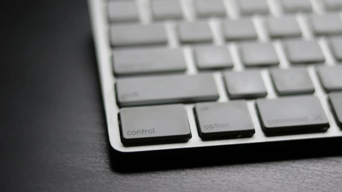 Detailed close-up of a sleek modern wireless keyboard on a dark surface.