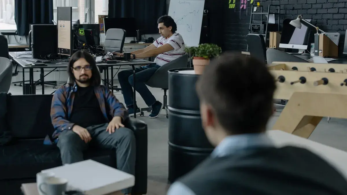 Team of professionals collaborating in a modern open office space with multiple workstations.