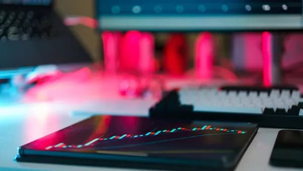 High-tech trading setup with charts on tablet and computer screens, representing data analysis and financial trends.