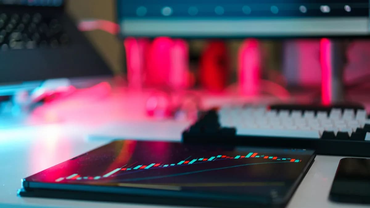 High-tech trading setup with charts on tablet and computer screens, representing data analysis and financial trends.