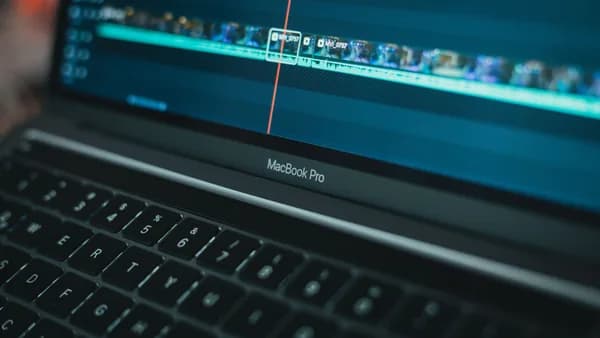 MacBook Pro with video editing software highlighting a timeline, showcasing technology in action.