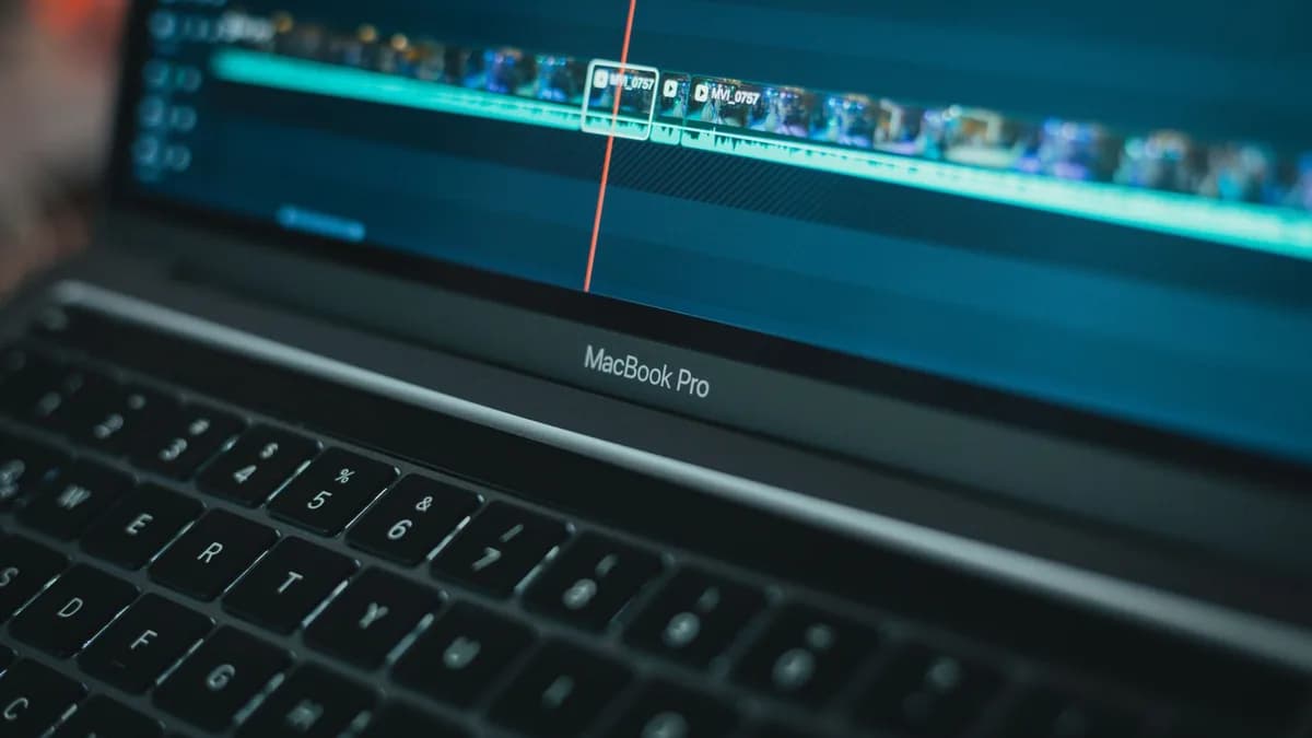 MacBook Pro with video editing software highlighting a timeline, showcasing technology in action.
