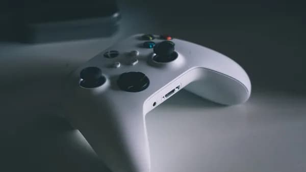 A detailed shot of a white gaming controller on a desk surface, perfect for tech and gaming themes.